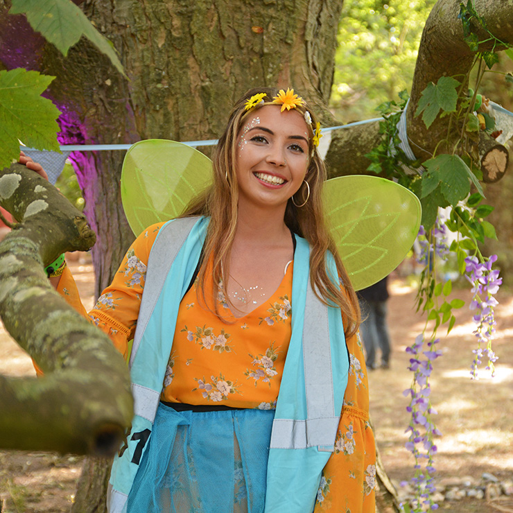 Volunteer at Camp Bestival 2020 with Hotbox Events - Volunteer standing with flowers