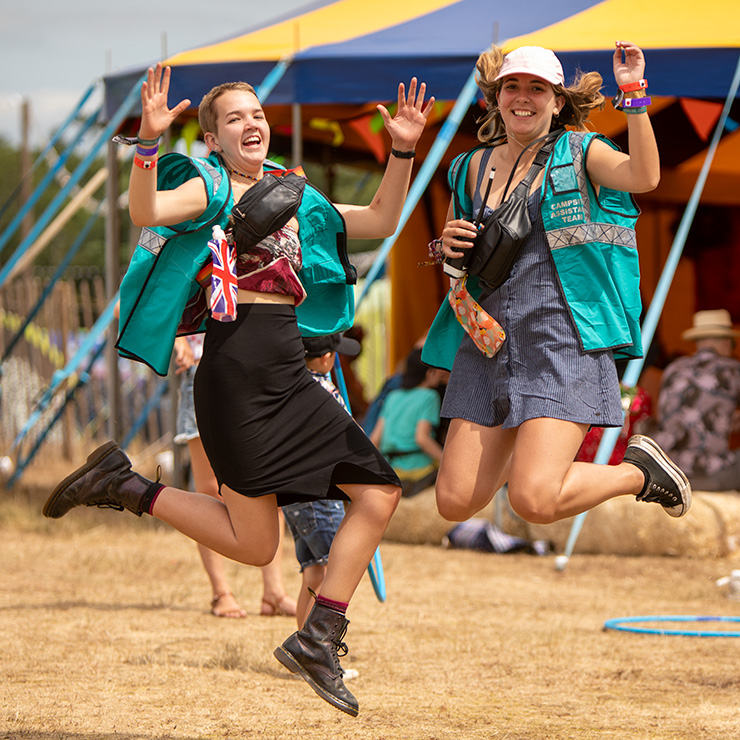Jobs and Volunteering at Camp Bestival Dorset 2022 with Hotbox Events - Arena volunteers jumping by big top - 2022-001 740PxSq72Dpi