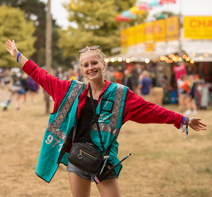 Jobs and Volunteering at Camp Bestival Dorset 2022 with Hotbox Events - Village volunteer with arms raised - 2022-001 740x686Px72Dpi
