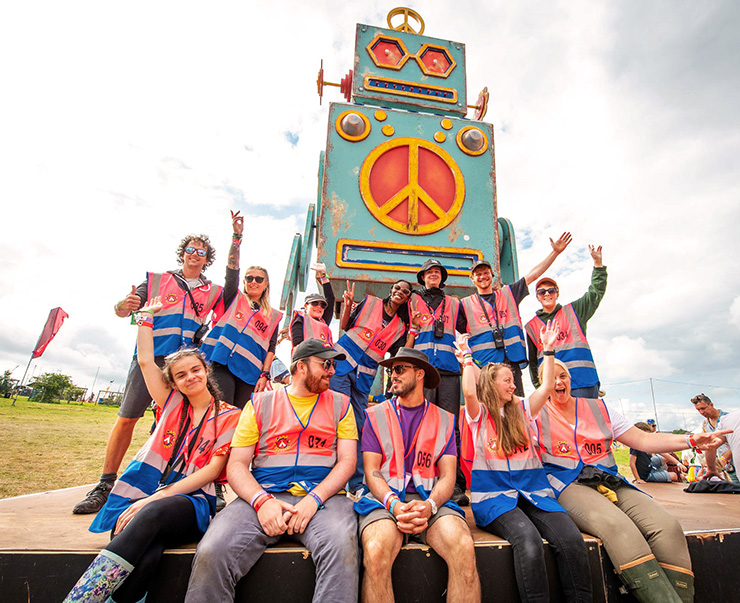 Jobs and Volunteering at Camp Bestival Dorset 2022 with Hotbox Events - Volunteers with robot in arena - 2022-001 740x603Px72Dpi