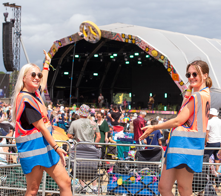 Jobs and Volunteering at Camp Bestival Dorset with Hotbox Events - Arena volunteers in front of main stage v2023001 740x657Px72Dpi
