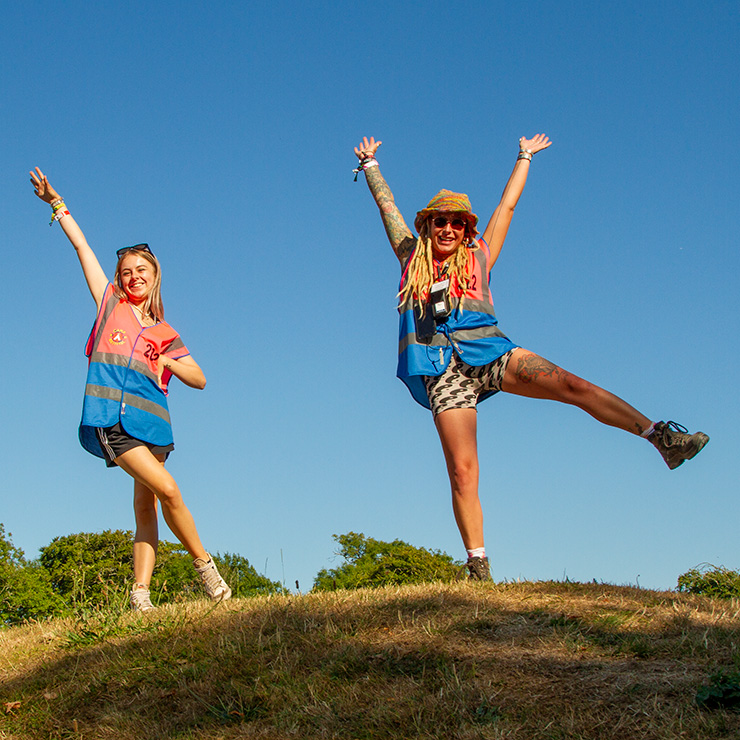 Jobs and Volunteering at Camp Bestival Dorset with Hotbox Events - Volunteers standing on hill with arms raised v2023001 740PxSq72Dpi