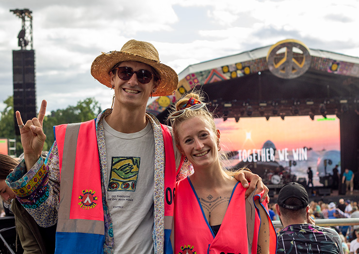 Jobs and Volunteering at Camp Bestival Shropshire with Hotbox Events - Arena volunteers in front of main stage v2023001 740x523Px72Dpi