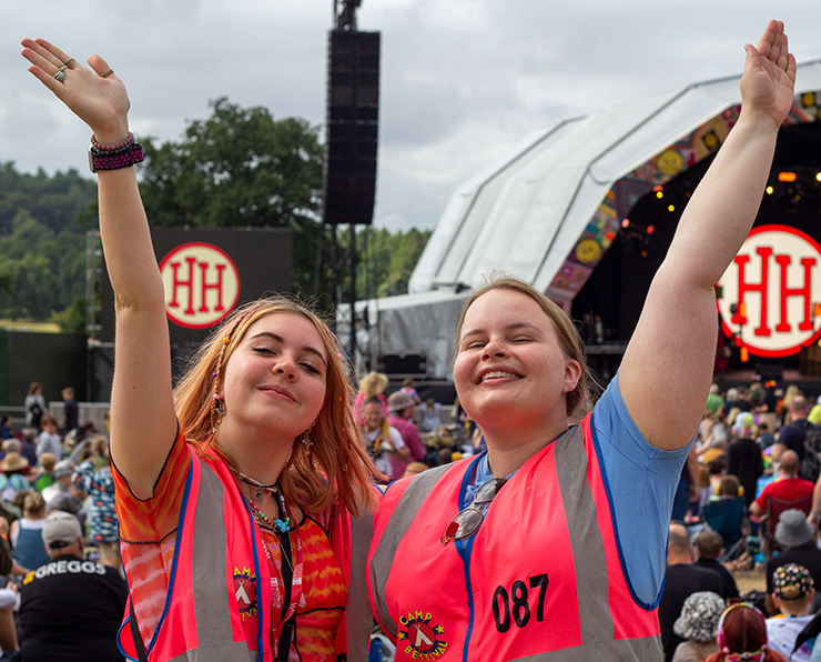 Jobs and Volunteering at Camp Bestival Shropshire with Hotbox Events - Arena volunteers on stage viewing platform v2023001 740x596Px72Dpi