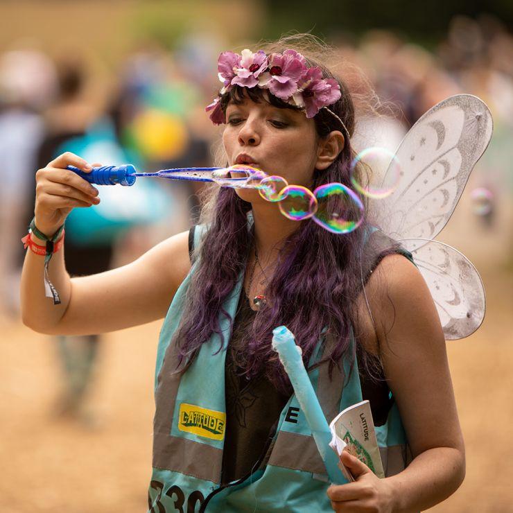 Jobs and Volunteering at Latitude Festival with Hotbox Events - Pixie volunteer with wings blowing bubbles v2022001 740PxSq72Dpi